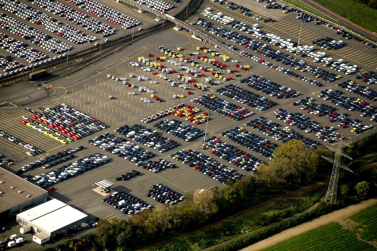 Luchtfoto van een groot terrein met pas geleverde nieuwe auto's bij Duisburg, die tot nu toe nog geen milieusticker hoeven te hebben