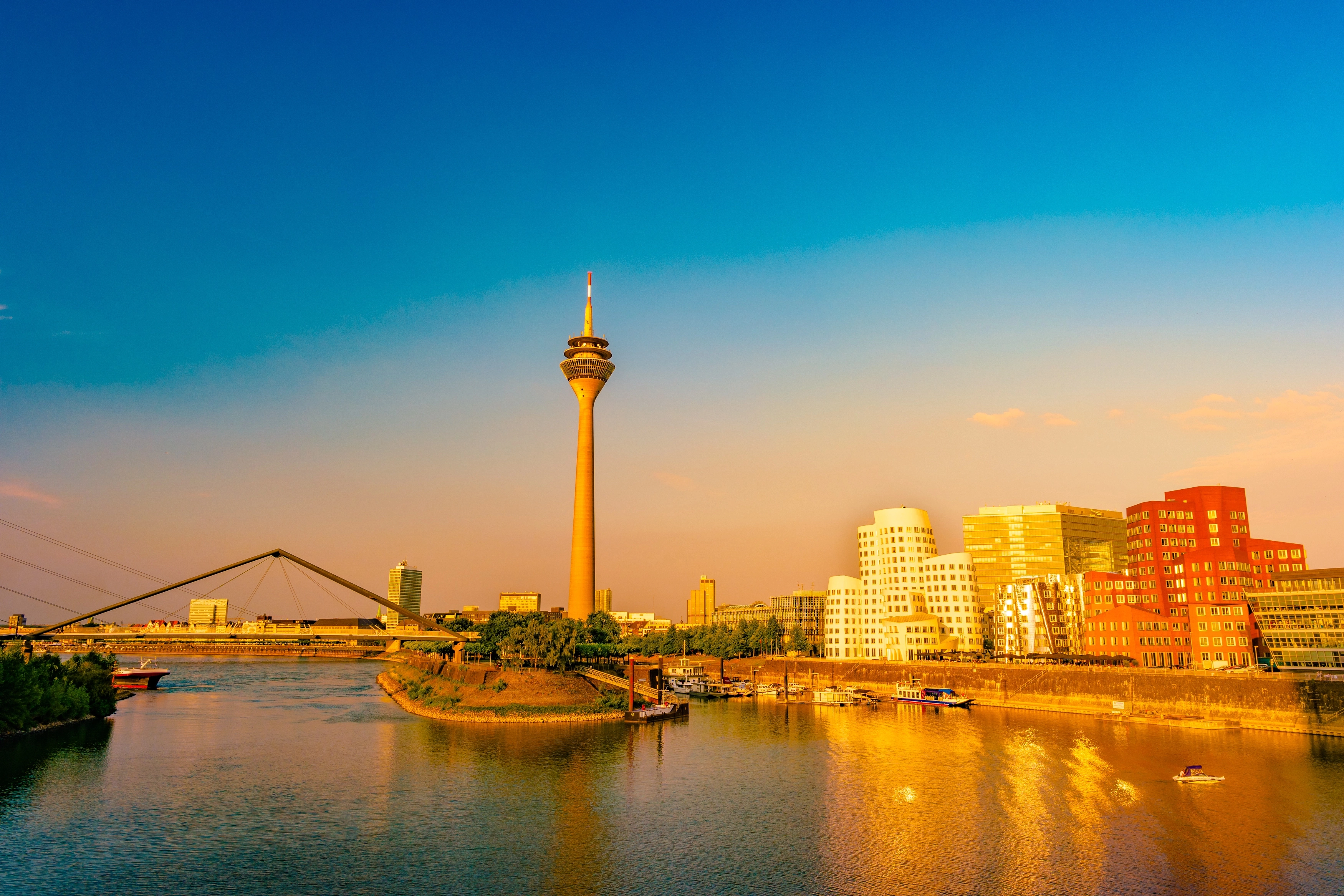 De Medienhafen van Düsseldorf met de Rheinturm en de Gehry-gebouwen in het avondlicht; binnen de milieuzone is een Umweltplakette verplicht