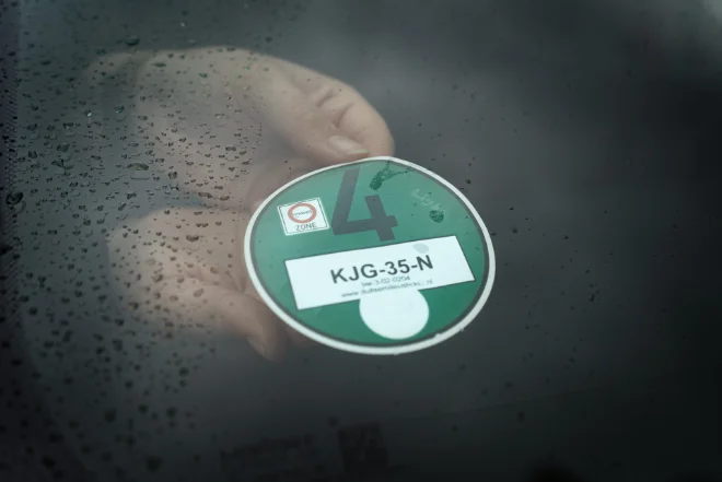 Plak de sticker aan de binnenkant van de voorruit, rechtsonder.